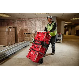 Image of a worker on a jobsite with the Milwaukee PACKOUT Rolling Tool Box and 40QT Cooler