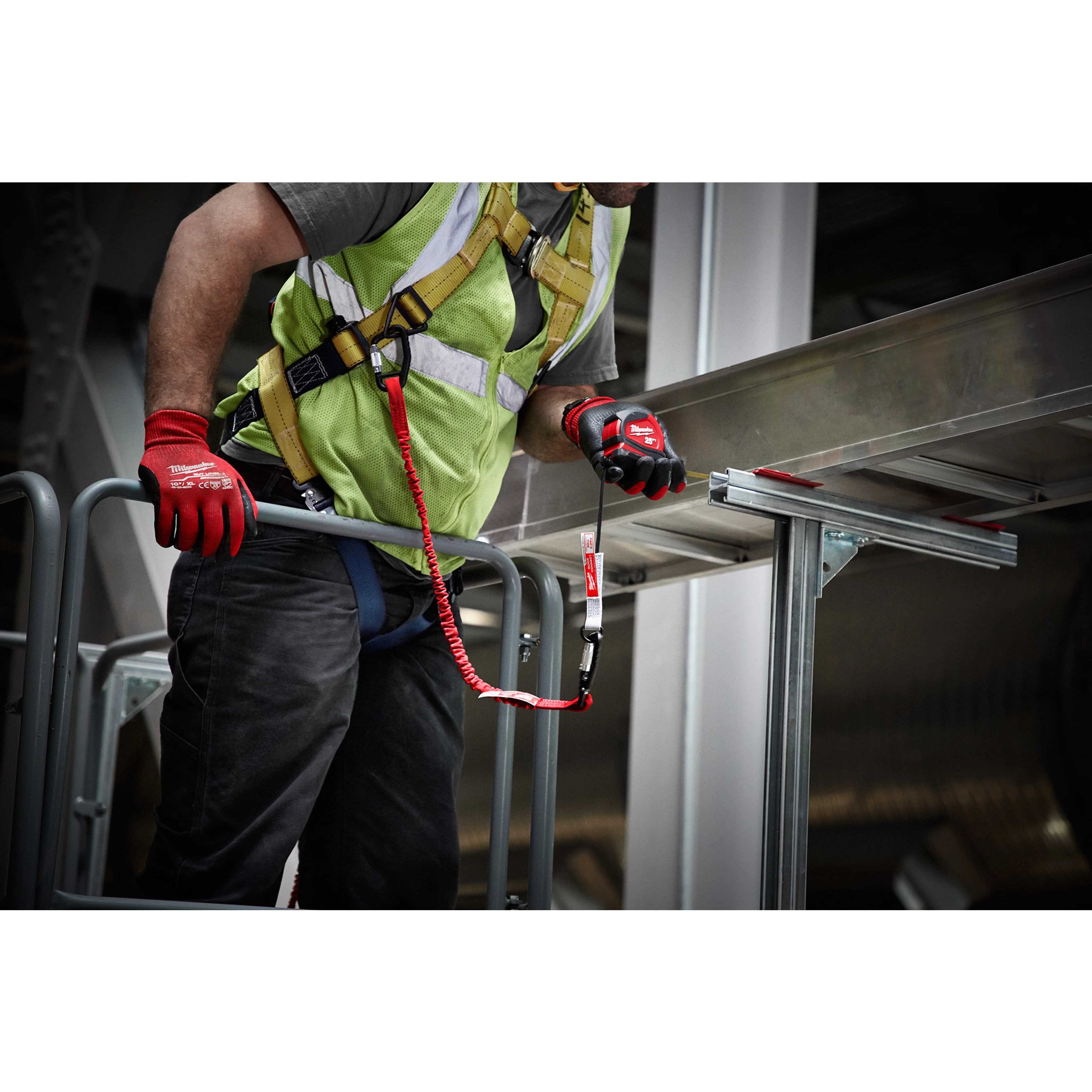 Worker using 10 LB QUICK-CONNECT Locking Tool Lanyard with 10 LB Accessory while wearing safety gear on scaffolding.