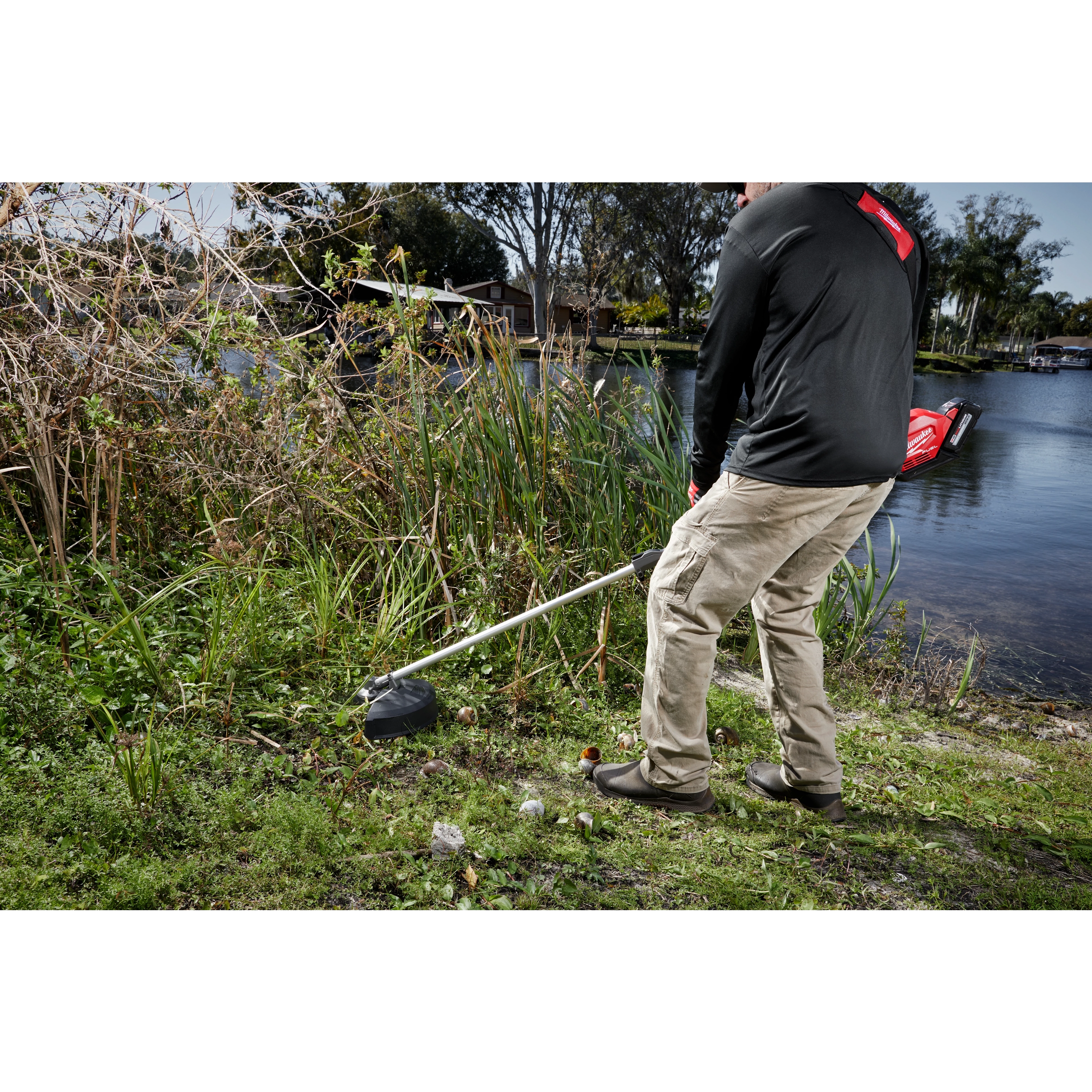 Worker using the M18 FUEL QUIK-LOK Brush Cutter Attachment