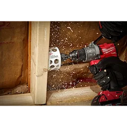 A 3-inch Hole Dozer with Carbide Teeth Hole Saw is mounted on a power drill, cutting through a wooden beam.