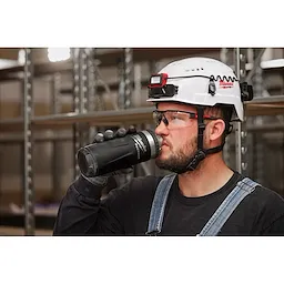 Image of a worker drinking from a Milwaukee PACKOUT Insulated Bottle with Chug Lid in black