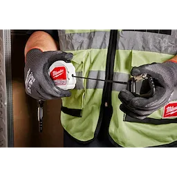 5LB Quick-Connect Retractable Tool Lanyard is being held by a person wearing a safety vest and gloves. The lanyard is extended and features a carabiner clip. The product is maximum load rated for 5 pounds and designed to prevent tool drops, ensuring safety on work sites.