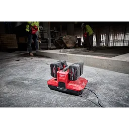 M18 & M12 Four Bay Simultaneous Super Charger with PACKOUT Compatibility, charging four batteries on a construction site.