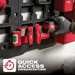 The PACKOUT Belt Clip Rack mounted on a black panel, holding various red tools, with a gloved hand retrieving a tape measure.