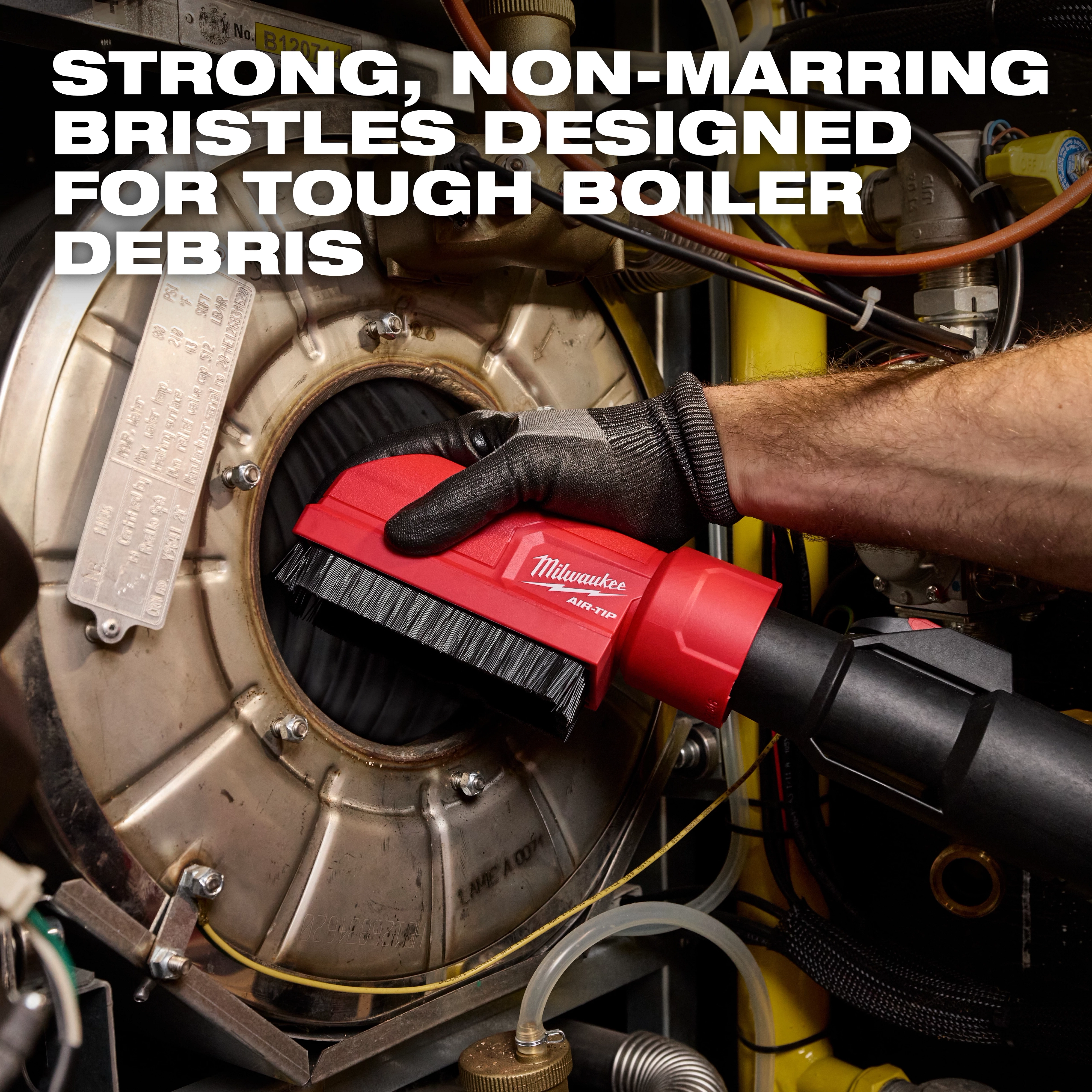 A person uses the AIR-TIP Boiler Coil Cleaning Brush Tool to clean a boiler, with strong bristles designed for tough debris.