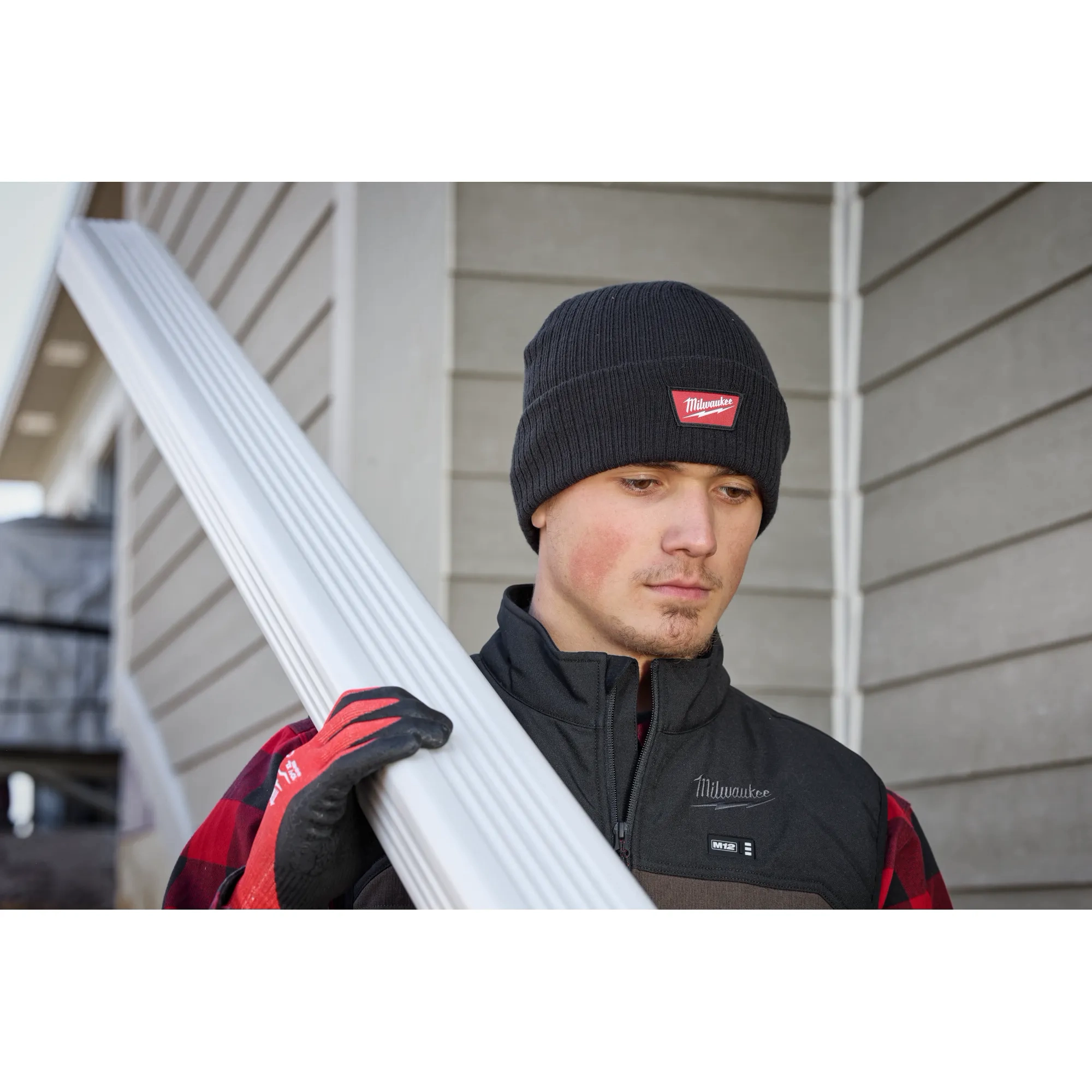 Image of a man on a jobsite wearing the Milwaukee Rib-Knit Cuffed Beanie in black