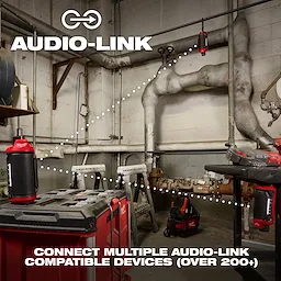 A workshop with an M12™ Bluetooth® Jobsite Speaker w/ PACKOUT™ Compatibility is displayed. The image highlights the connectivity feature "Audio-Link" with multiple speakers linked through dotted lines. The text reads, "CONNECT MULTIPLE AUDIO-LINK COMPATIBLE DEVICES (OVER 200+)." Various tools are also visible in the background.