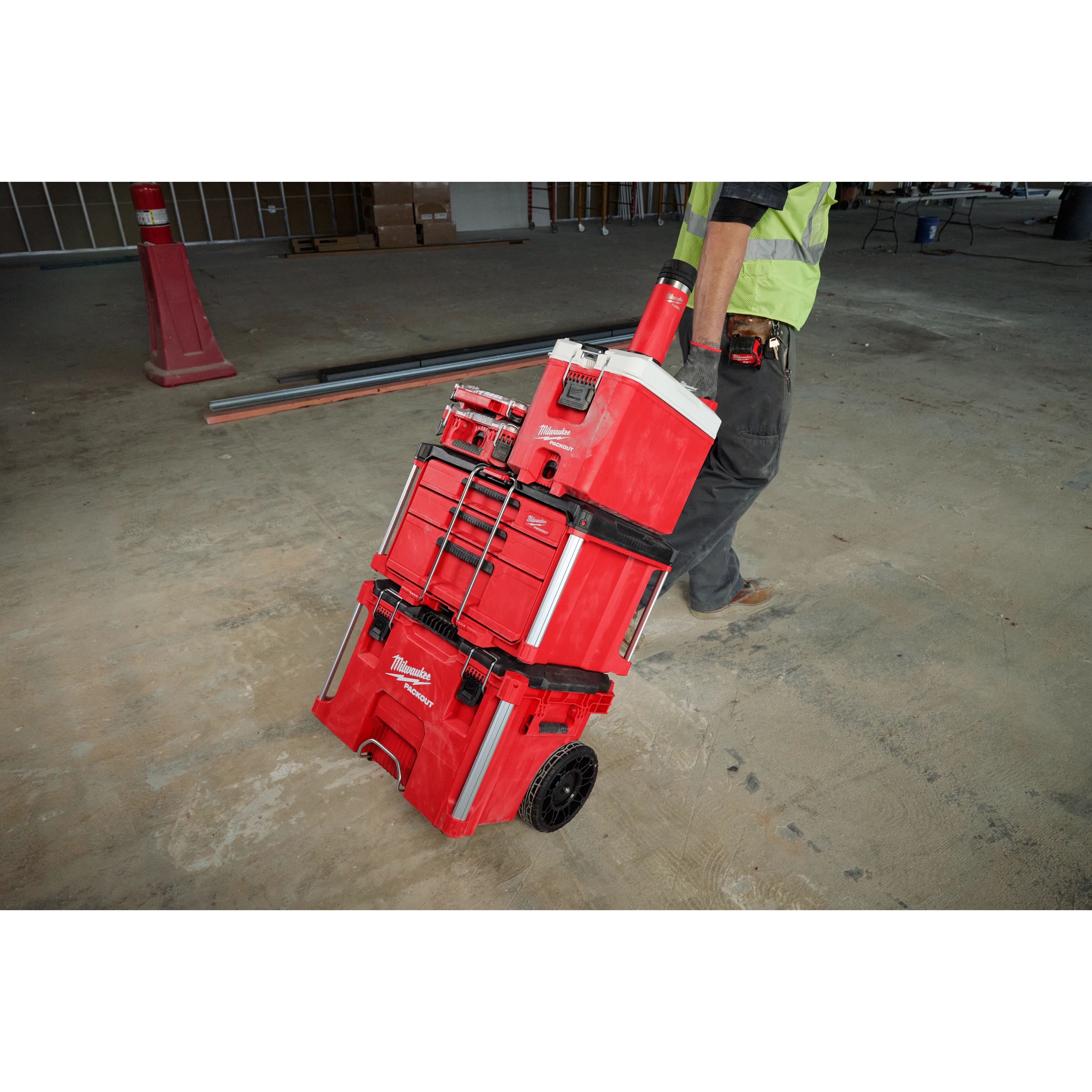 PACKOUT 18oz Insulated Bottle with Sip Lid is attached to a red tool storage system, being wheeled by a person on a worksite.