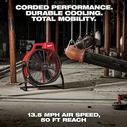 The image shows the M18 Brushless 18 in. Fan in a rugged industrial setting. Text emphasizes its features: "Corded Performance. Durable Cooling. Total Mobility." At the bottom, additional text states, "13.5 mph air speed, 50 ft reach." The fan has a red and black design.