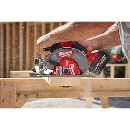 6-1/2” 24T NITRUS Carbide Framing & Demolition Circular Saw Blade cutting through a wooden board outdoors.