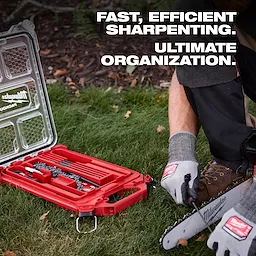 A person sharpens a saw chain using the 9pc Saw Chain Sharpening Set with PACKOUT™ Low-Profile Compact Organizer. The set includes files and tools, housed in a red, durable organizer for efficient sharpening and superior organization. The image emphasizes the ease and efficiency of use in a grassy outdoor area.