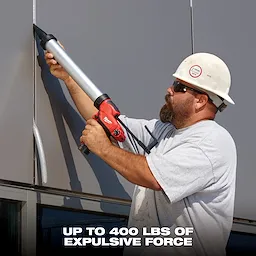 A construction worker uses an M12 12-Volt Lithium-Ion Cordless 10 oz. Caulk and Adhesive Gun (Tool-Only) on a metal panel. The text at the bottom reads "Up to 400 lbs of expulsive force."