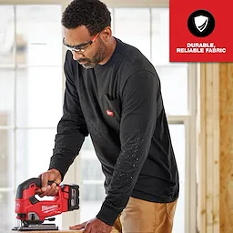 A person wearing a GRIDIRON Pocket T-Shirt - Long Sleeve, holding a red and black power tool, with "Durable, Reliable Fabric" text.