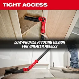 A person uses the AIR-TIP™ Low-Profile Pivoting Brush Tool to clean a tight space under and inside a cabinet. The low-profile pivoting design allows for greater access in confined areas. The image highlights the tool’s functionality in providing tight access cleaning.