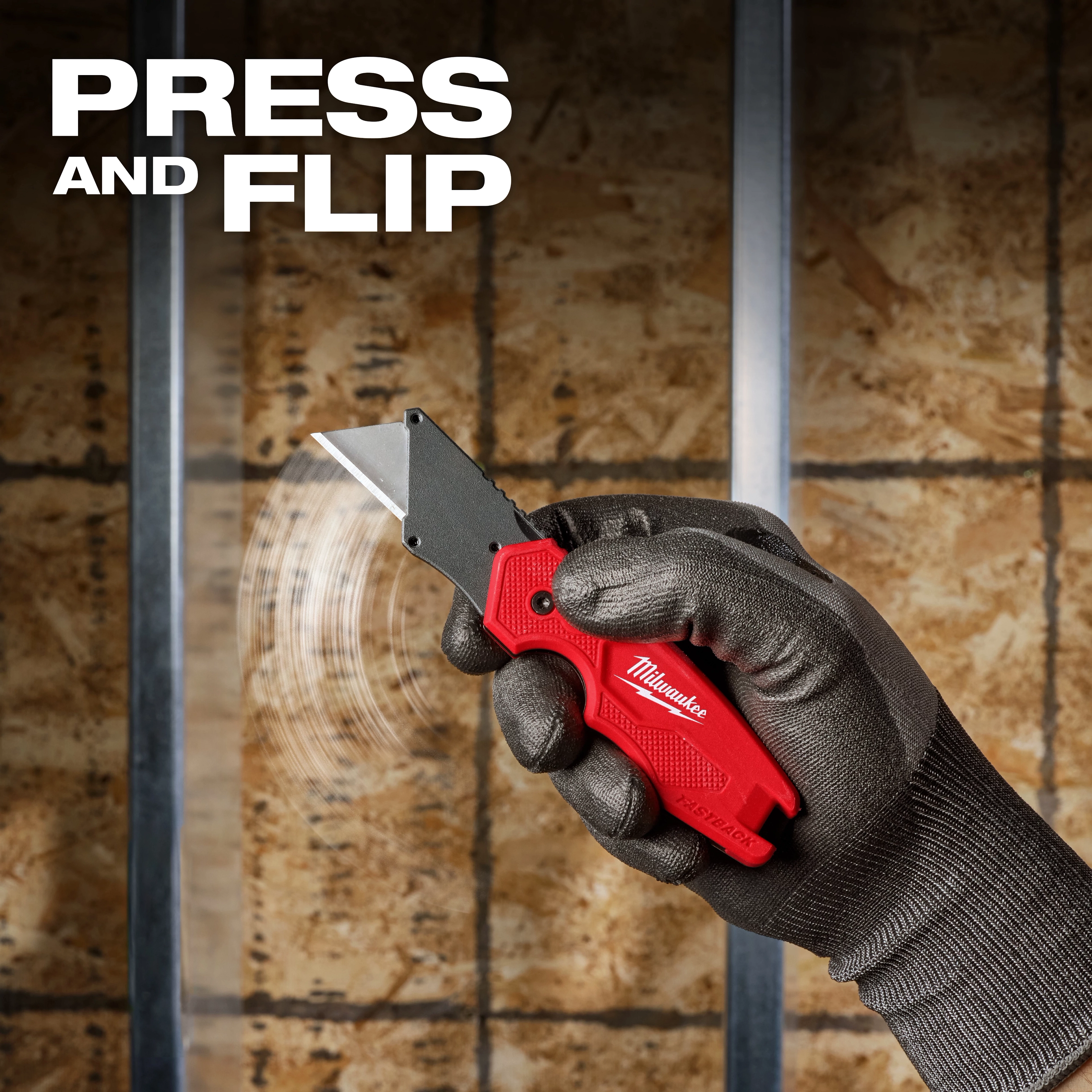 Gloved hand flipping open a FASTBACK Compact Folding Utility Knife against a construction wall.