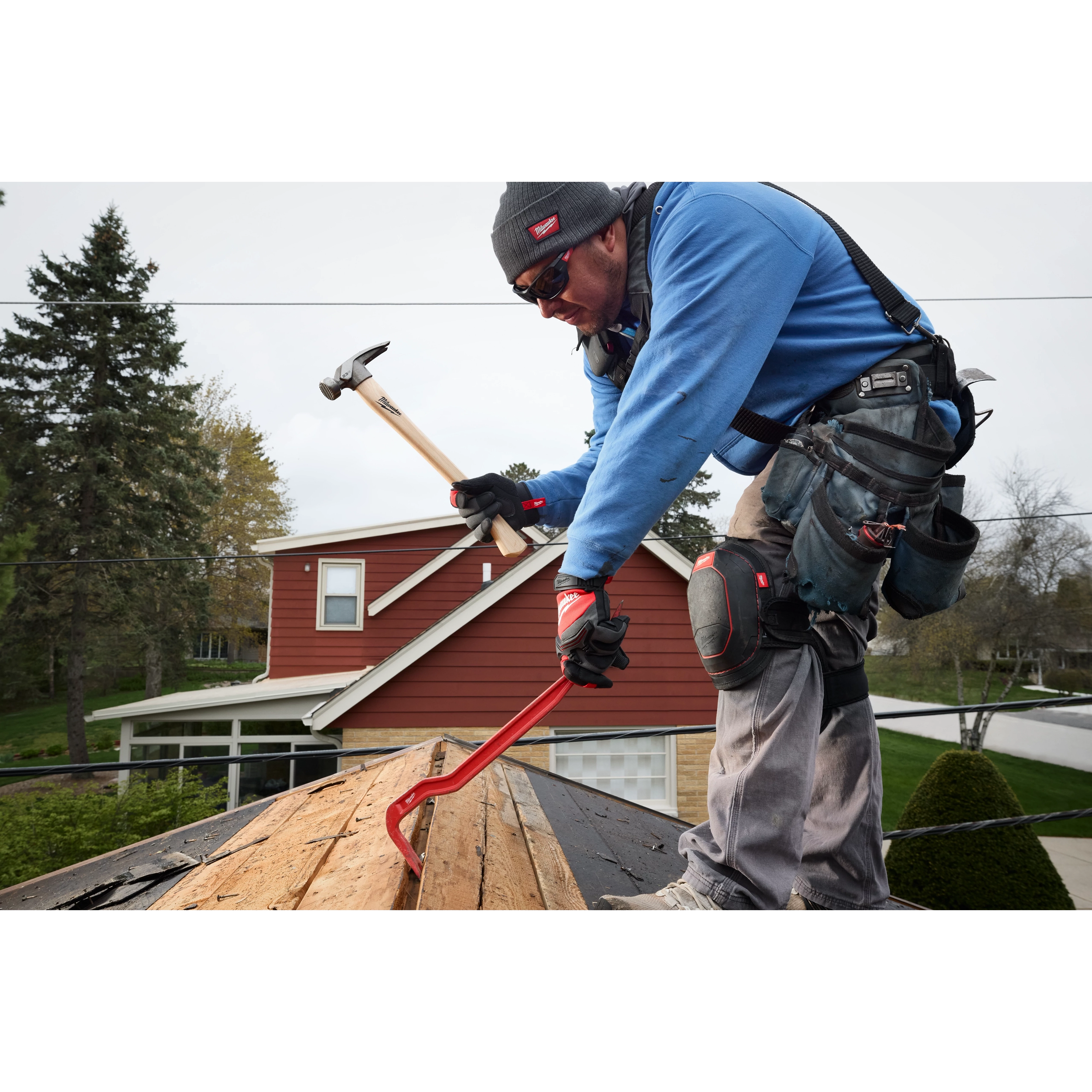 Worker using a 23oz Milled Face Hickory Handle Framing Hammer while repairing a house roof.
