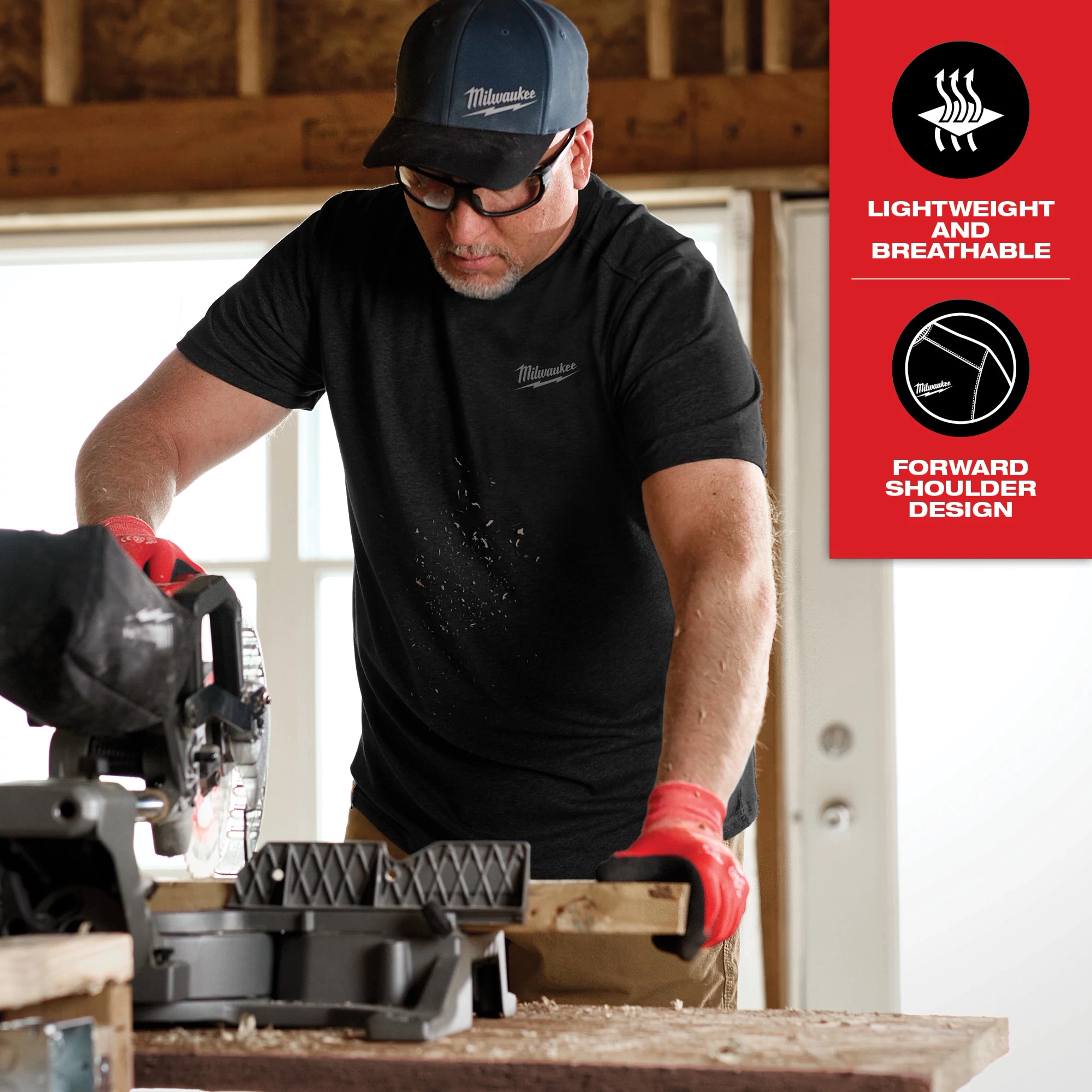 Hybrid Work Tee - Short Sleeve Feature Shot. A person is using a power saw while wearing a black short-sleeve tee, featuring lightweight and breathable fabric with forward shoulder design.