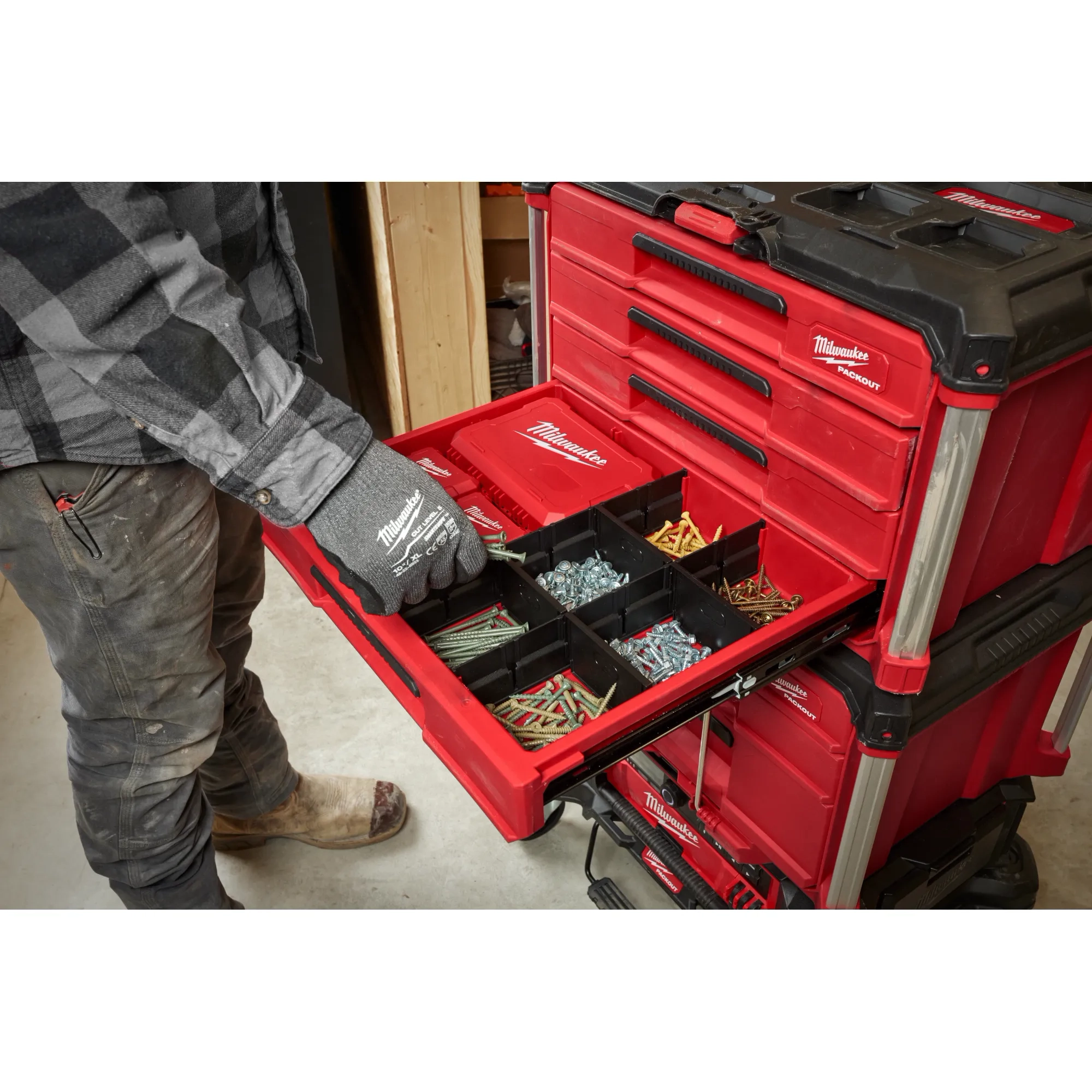 Worker utilizing the PACKOUT 4-Drawer Tool Box to store screws