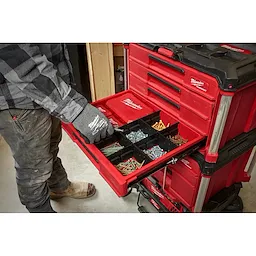 Worker utilizing the PACKOUT 4-Drawer Tool Box to store screws