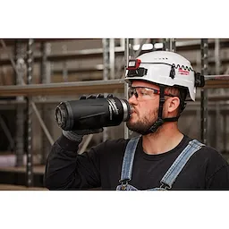 Image of a worker drinking from a Milwaukee PACKOUT Insulated Bottle with Chug Lid in black