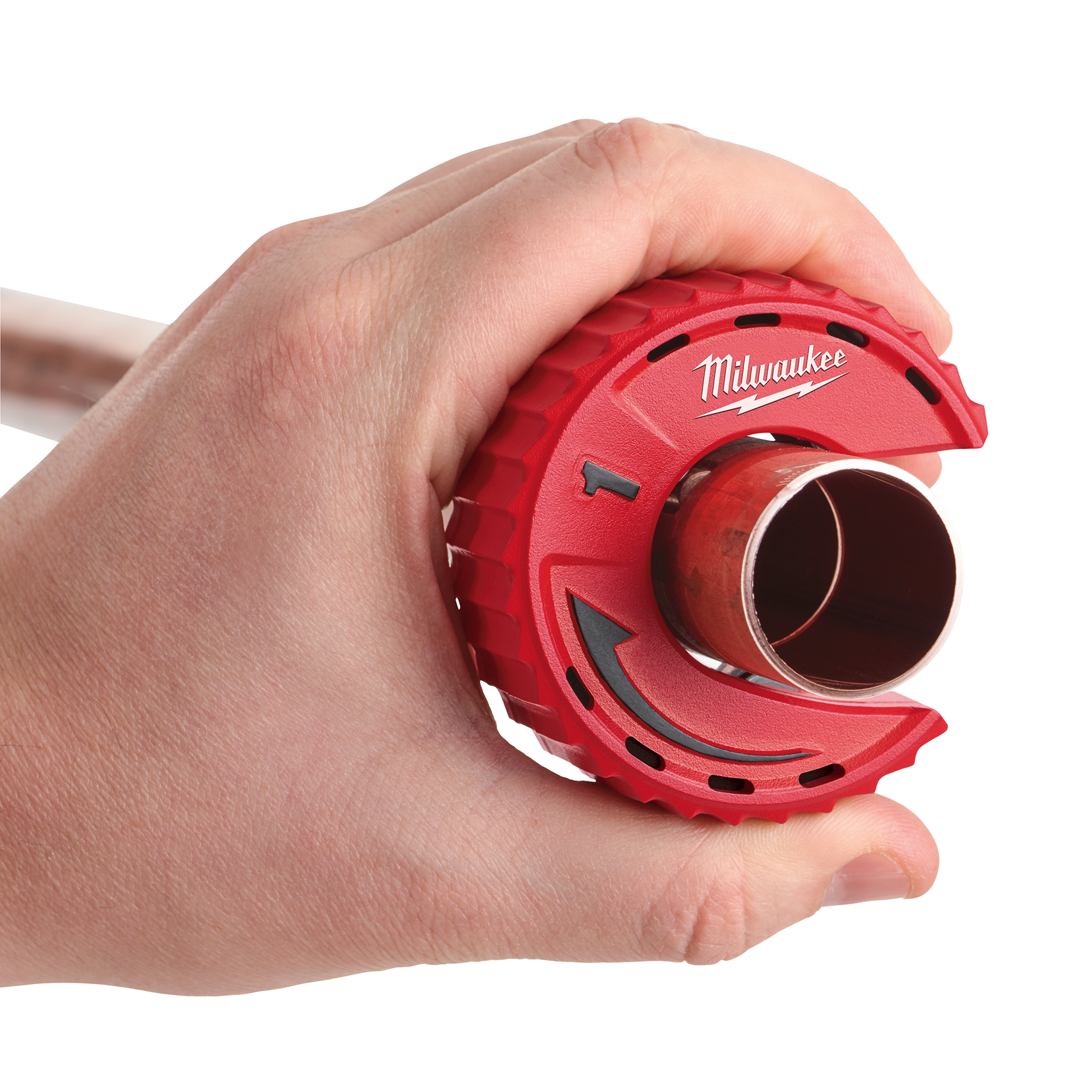A hand holds a Milwaukee Close Quarters Tubing Cutter around a copper pipe, showcasing the red cutting tool’s compact design.