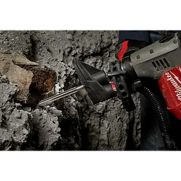 A person uses the SDS-Plus SLEDGE 10" Bull Point Chisel attached to a power tool to break through concrete.