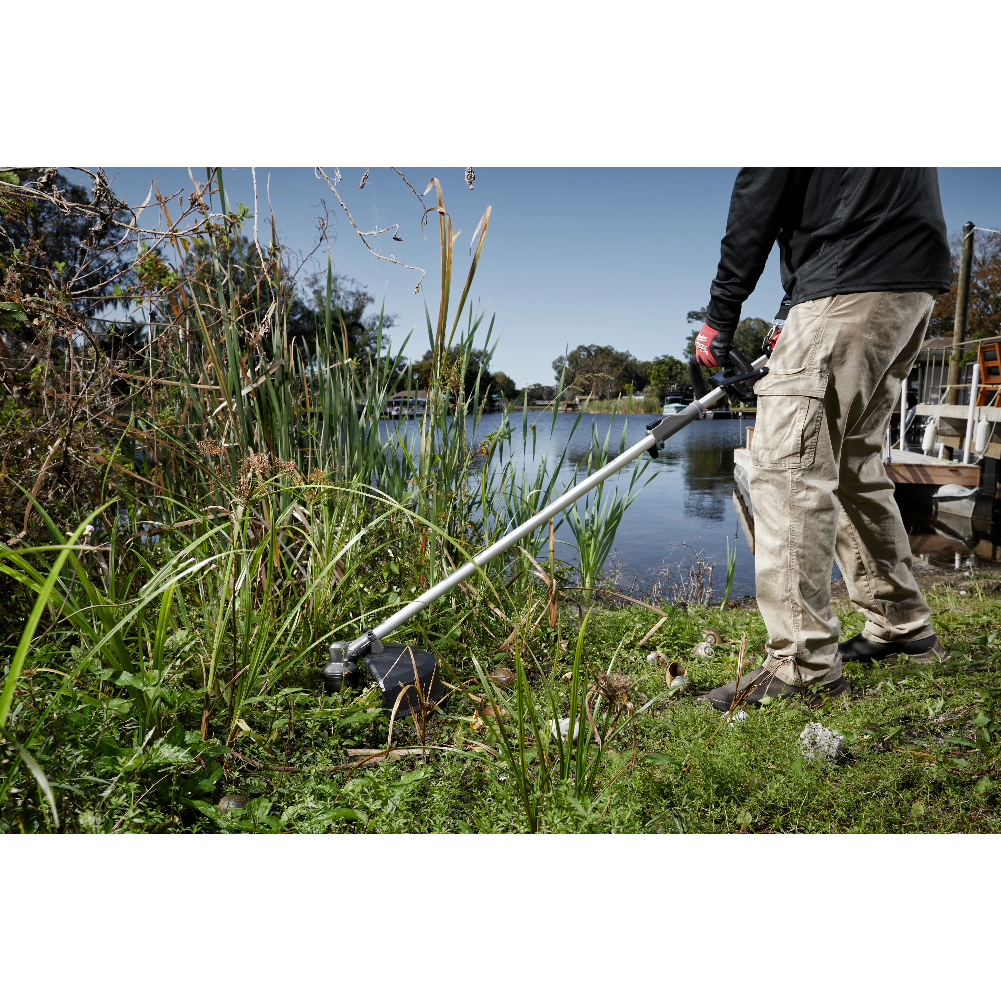 Worker using the M18 FUEL QUIK-LOK Brush Cutter Attachment