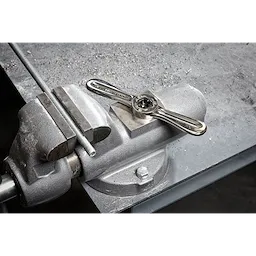 Hex-LOK 2-in-1 Threading Handle on a metal workbench, clamped, ready for use in threading operations.
