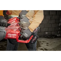 A person using the M18 FUEL™ Pipe Threader w/ ONEKEY. The image shows multiple positions of the handle to demonstrate its versatility. The tool is red and black with "Milwaukee FUEL" branding visible. The user is wearing gloves with the "Milwaukee" logo on them.