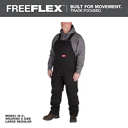 Man wearing FREEFLEX Insulated Bib Overalls with a grey hoodie underneath. Caption reads: "Model is 6', wearing a size Large Regular."