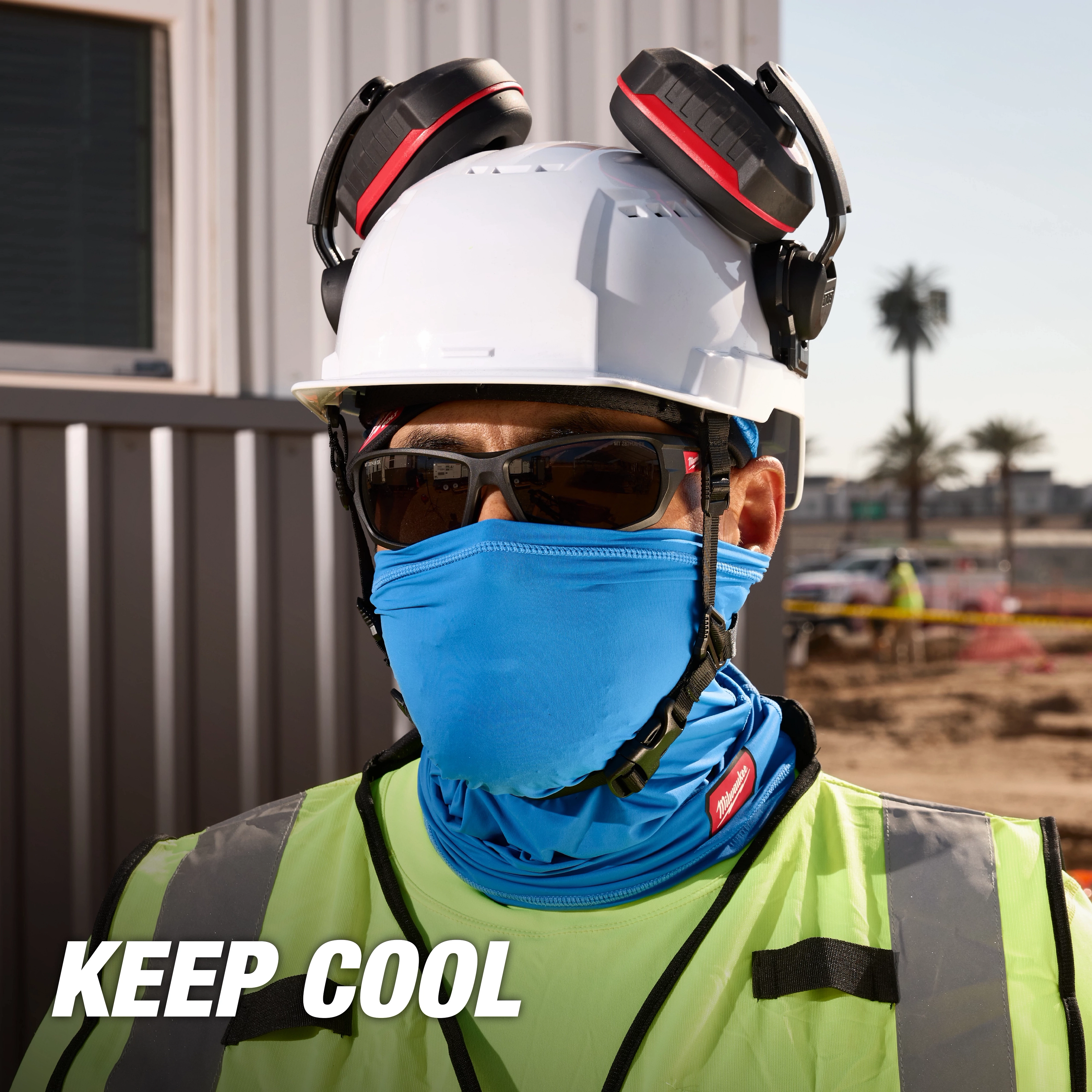 Worker wearing a hard hat with earmuffs, reflective vest, and a blue Cooling Neck Gaiter. Text overlay reads "KEEP COOL".