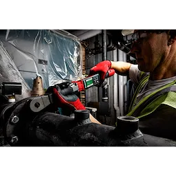 Worker using the M12 FUEL 1/2" Digital Torque Wrench with ONE-KEY App Shot to tighten a pipe fitting in an industrial setting.
