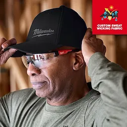 WORKSKIN Performance Fitted Hat being worn, featuring a dark color and logo. UPF 50+ sun protection icon in the top right.