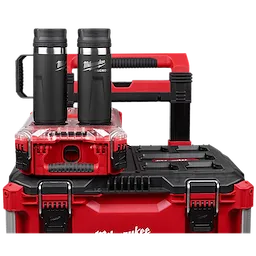 The PACKOUT™ 18oz Insulated Bottle with Sip Lid is shown placed on a robust red and black toolkit system. Two black and silver insulated bottles are visible, highlighted by their ergonomic handles and secure lids. The setup emphasizes durability and organization for professional use.