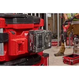 PACKOUT Tool Box M18 Battery Rack Attachment holding an M18 battery, attached to a red and black PACKOUT Tool Box system