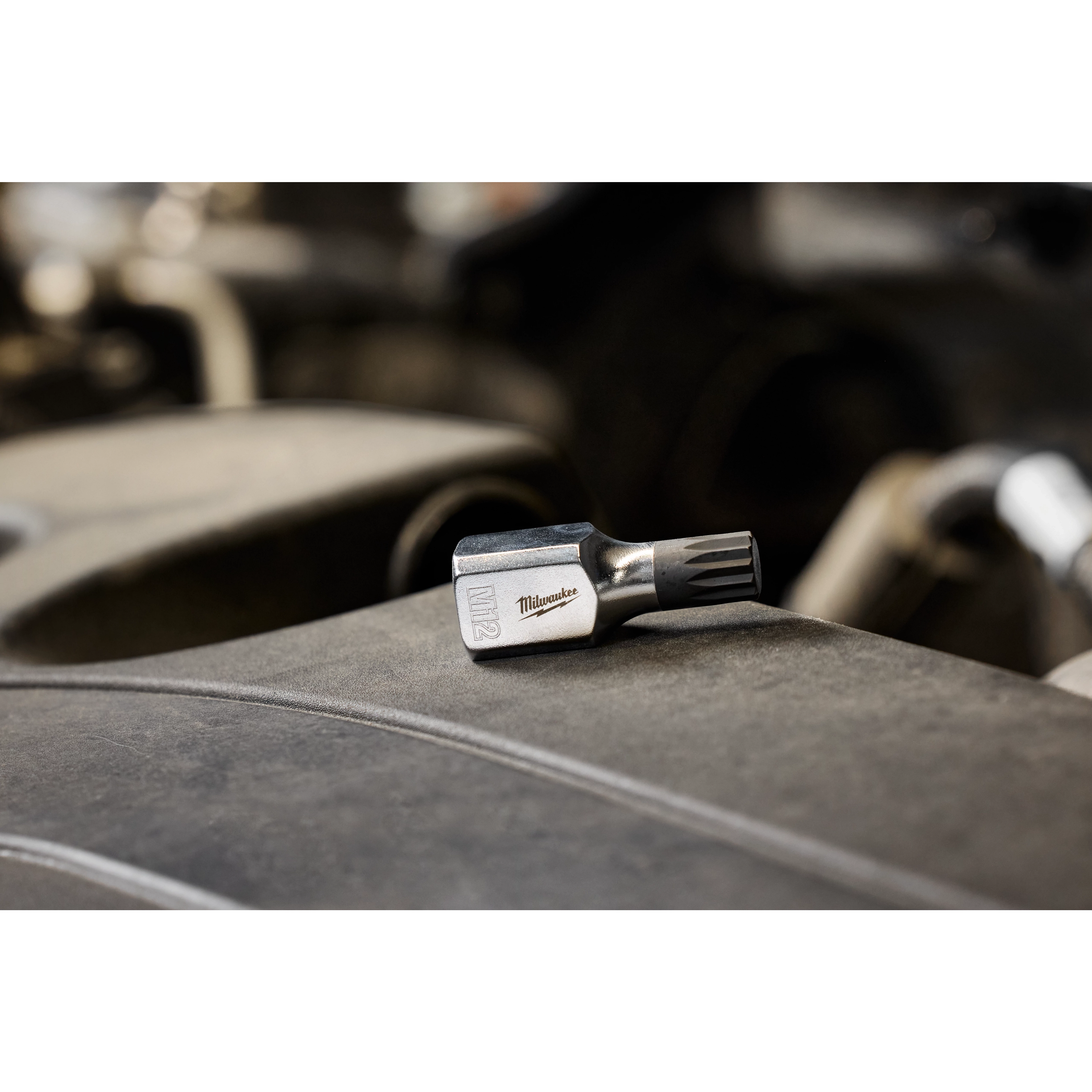 3/8" Drive 12mm Triple Square Bit Socket with engraved label lies on a dusty surface in an industrial setting.