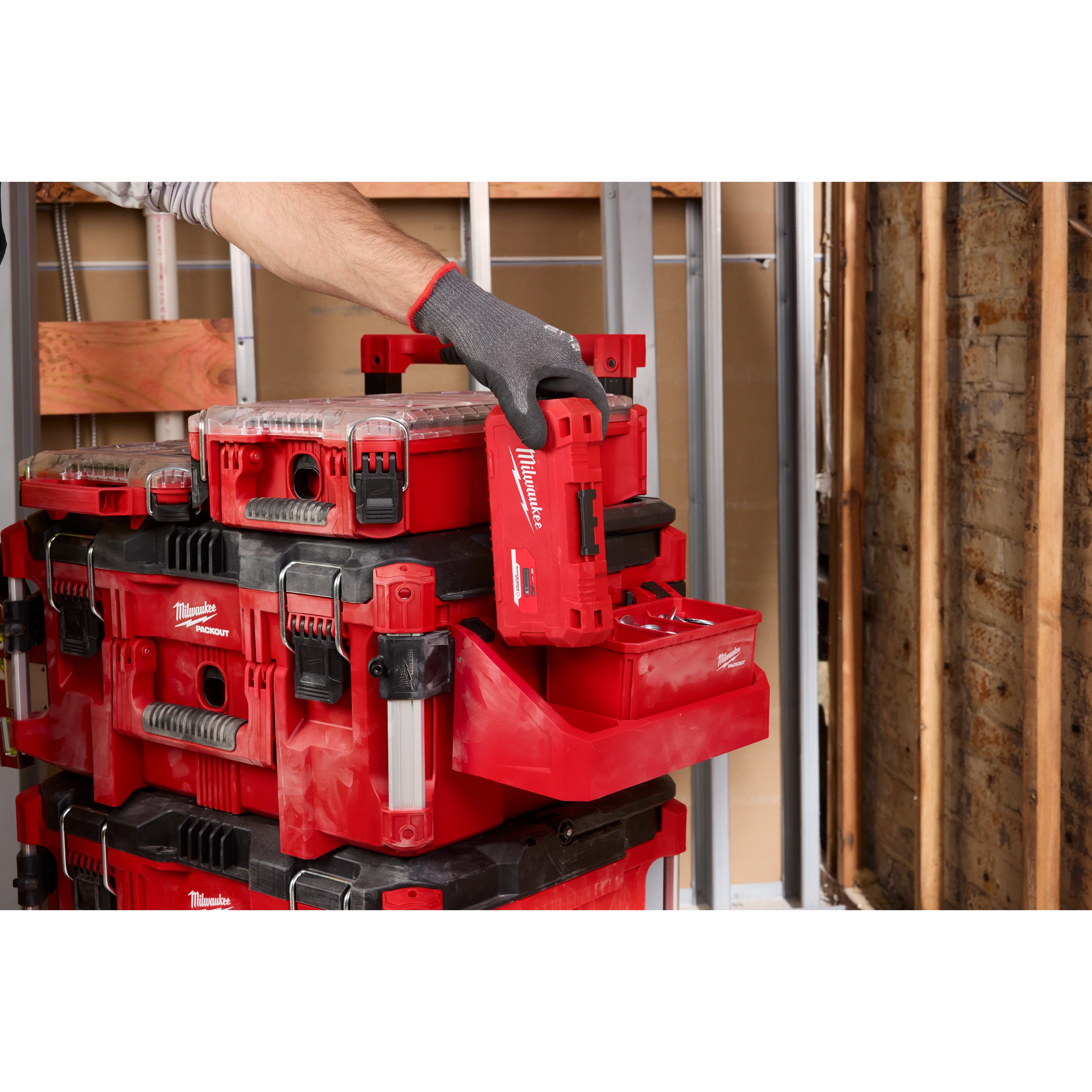 Attaching a red PACKOUT Tool Box Tray Attachment to a stack of PACKOUT toolboxes