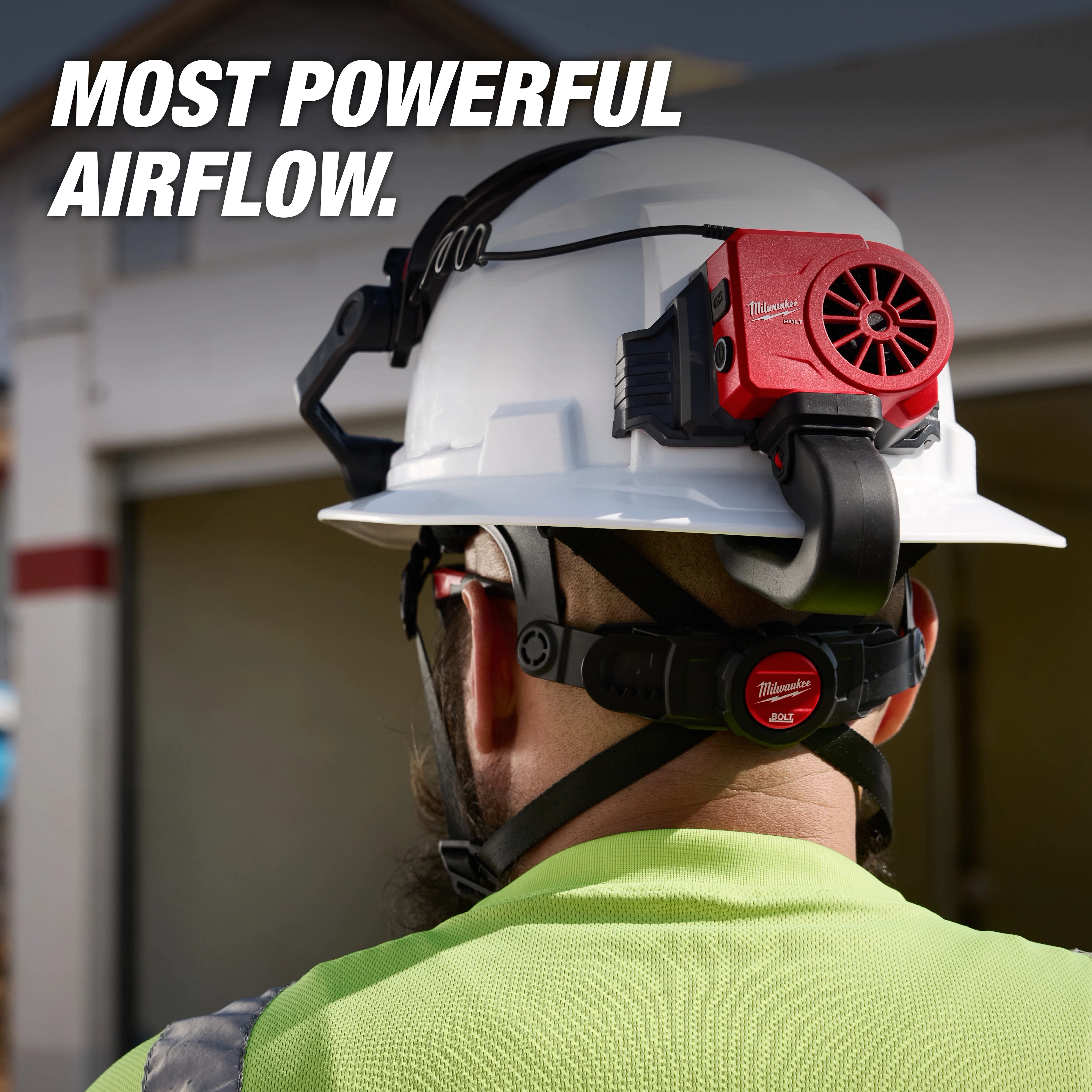 Worker wearing a hard hat with the BOLT REDLITHIUM USB Cooling Fan attached to the back, showcasing powerful airflow.