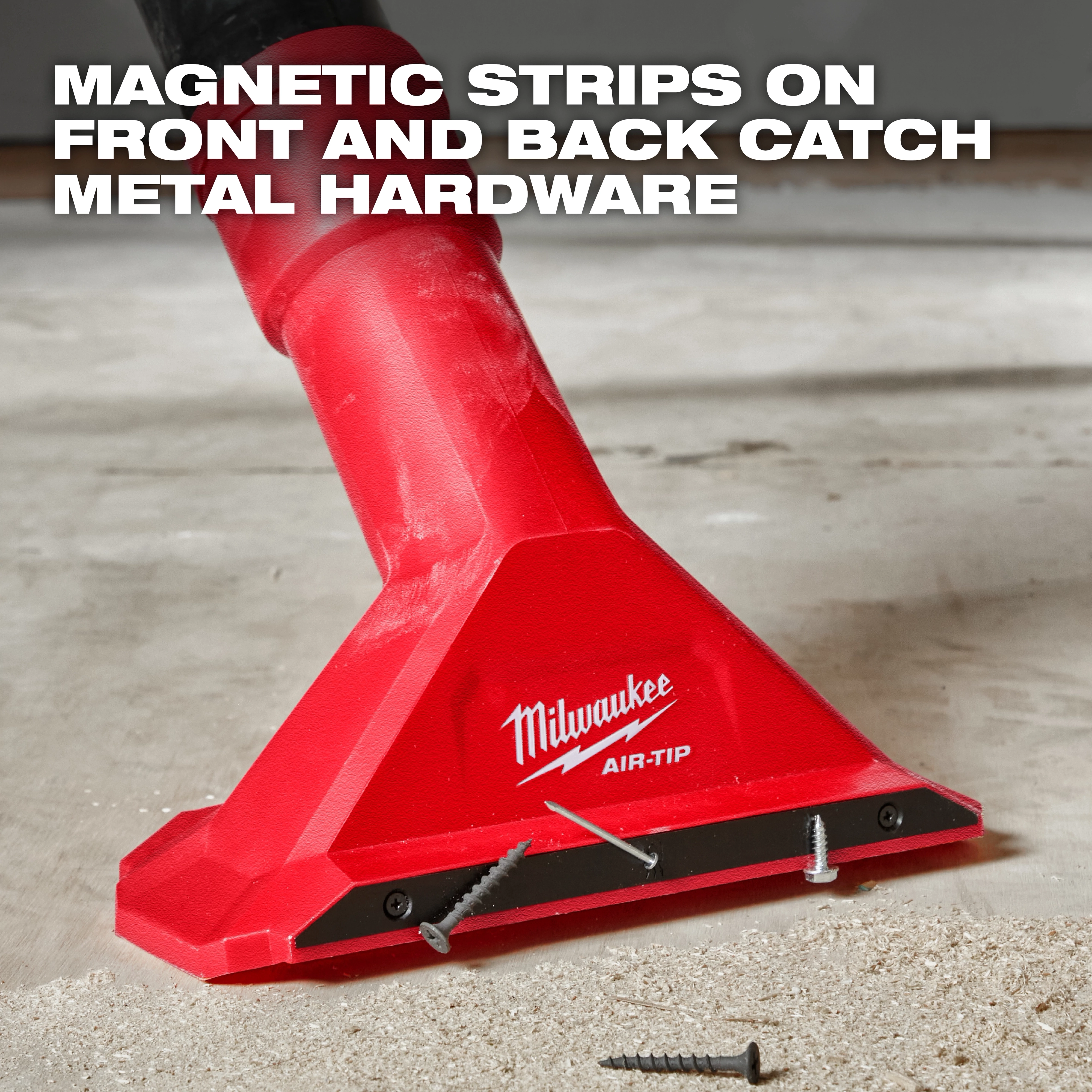 A red Milwaukee AIR-TIP™ 2 1/2" Magnetic Utility Nozzle is shown picking up screws from a floor. Text at the top states, "MAGNETIC STRIPS ON FRONT AND BACK CATCH METAL HARDWARE." The nozzle is attached to a vacuum cleaner and has screws adhered to its magnetic strip.