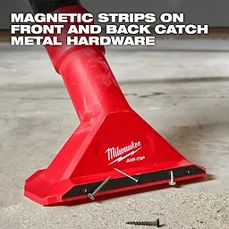 A red Milwaukee AIR-TIP™ 2 1/2" Magnetic Utility Nozzle is shown picking up screws from a floor. Text at the top states, "MAGNETIC STRIPS ON FRONT AND BACK CATCH METAL HARDWARE." The nozzle is attached to a vacuum cleaner and has screws adhered to its magnetic strip.