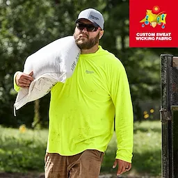 A person wearing a neon yellow WORKSKIN Hooded Sun Shirt is carrying a large white sack over their shoulder. The shirt features custom sweat-wicking fabric, as indicated by the graphic in the upper right corner.