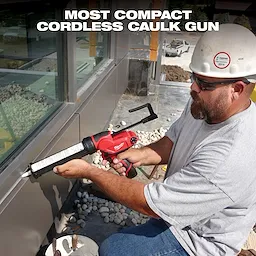 A worker uses the M12 12-Volt Lithium-Ion Cordless 10 oz. Caulk and Adhesive Gun (Tool-Only) to apply sealant to a building's exterior window frame. The image includes the text "Most Compact Cordless Caulk Gun."