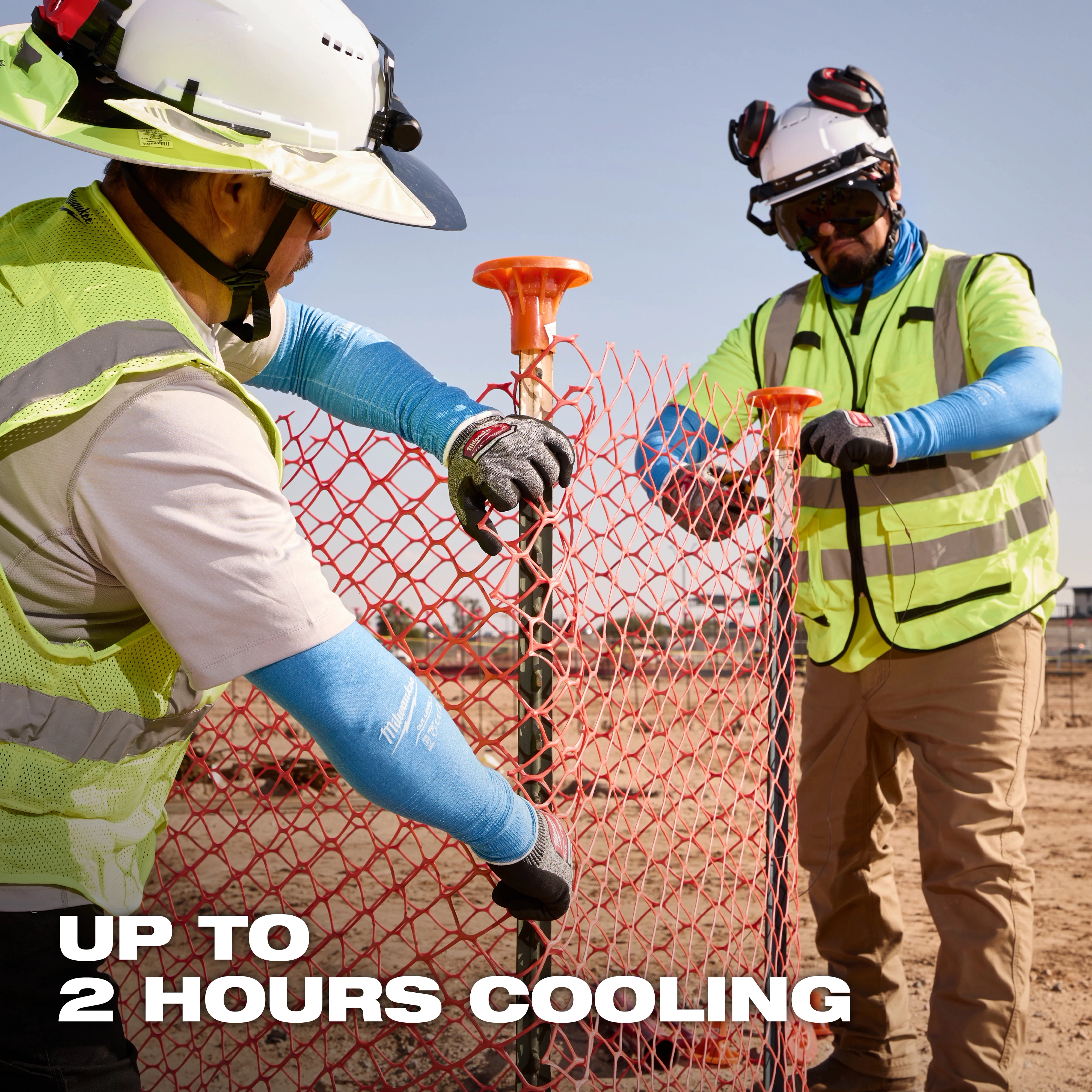 Workers wearing Cooling Cut Level 1 Protective Sleeves - 16" adjust an orange barrier fence at a construction site. Text reads "Up to 2 hours cooling."