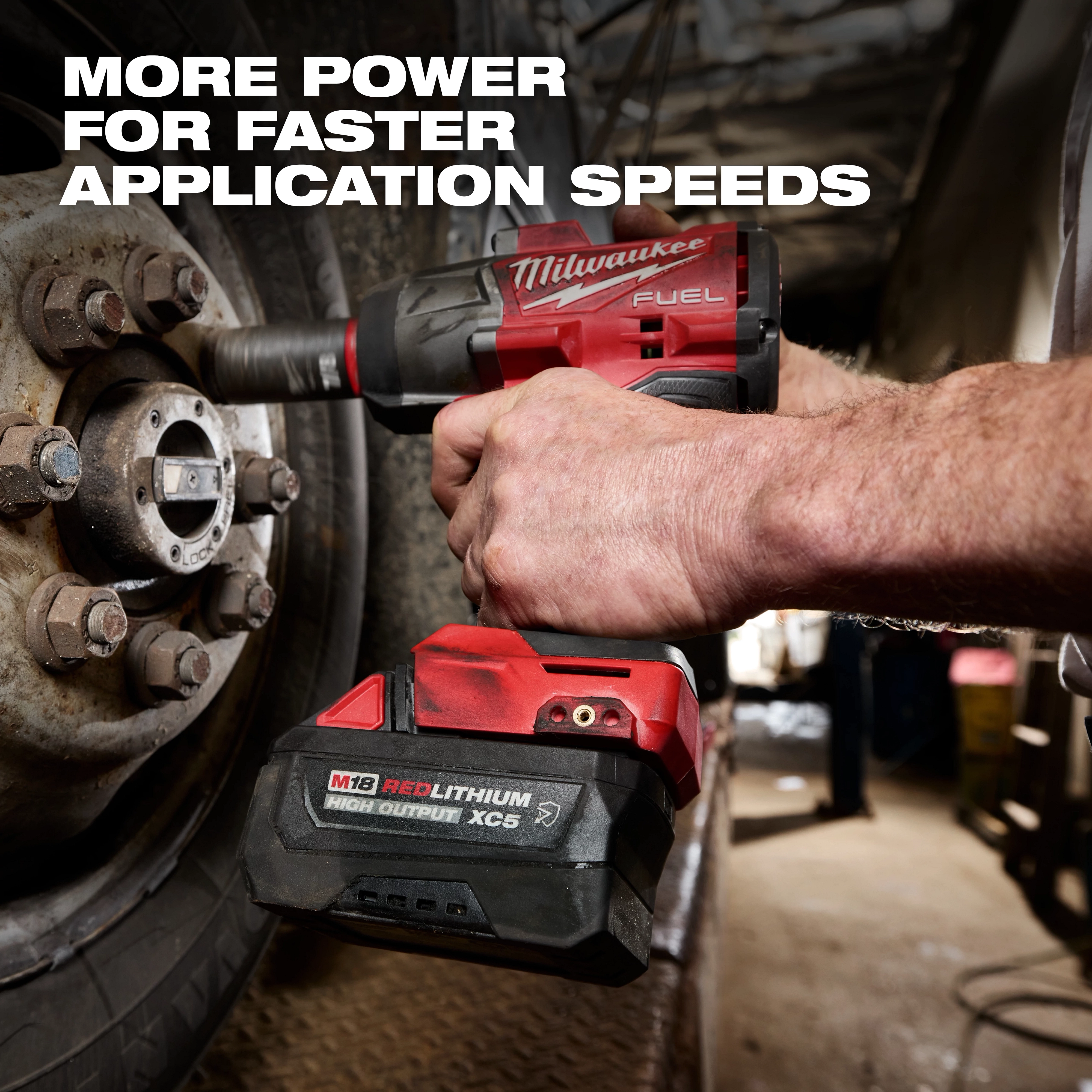 M18 REDLITHIUM HIGH OUTPUT XC5 Resistant Battery Pack attached to a power tool tightening lug nuts on a vehicle wheel.