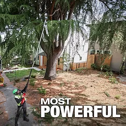 A worker uses the M18 FUEL™ Telescoping Pole Saw to trim branches high up in a large tree. The background shows a residential yard with houses, and the words "MOST POWERFUL" are prominently displayed at the bottom of the image.