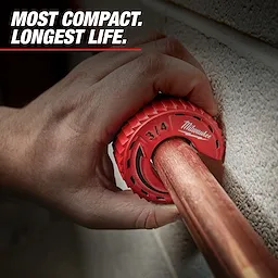 A hand uses the Milwaukee 3/4-inch copper tubing cutter on a pipe. The background text reads, "Most compact. Longest life." The tool is red and designed for ease of pipe cutting in tight spaces.
