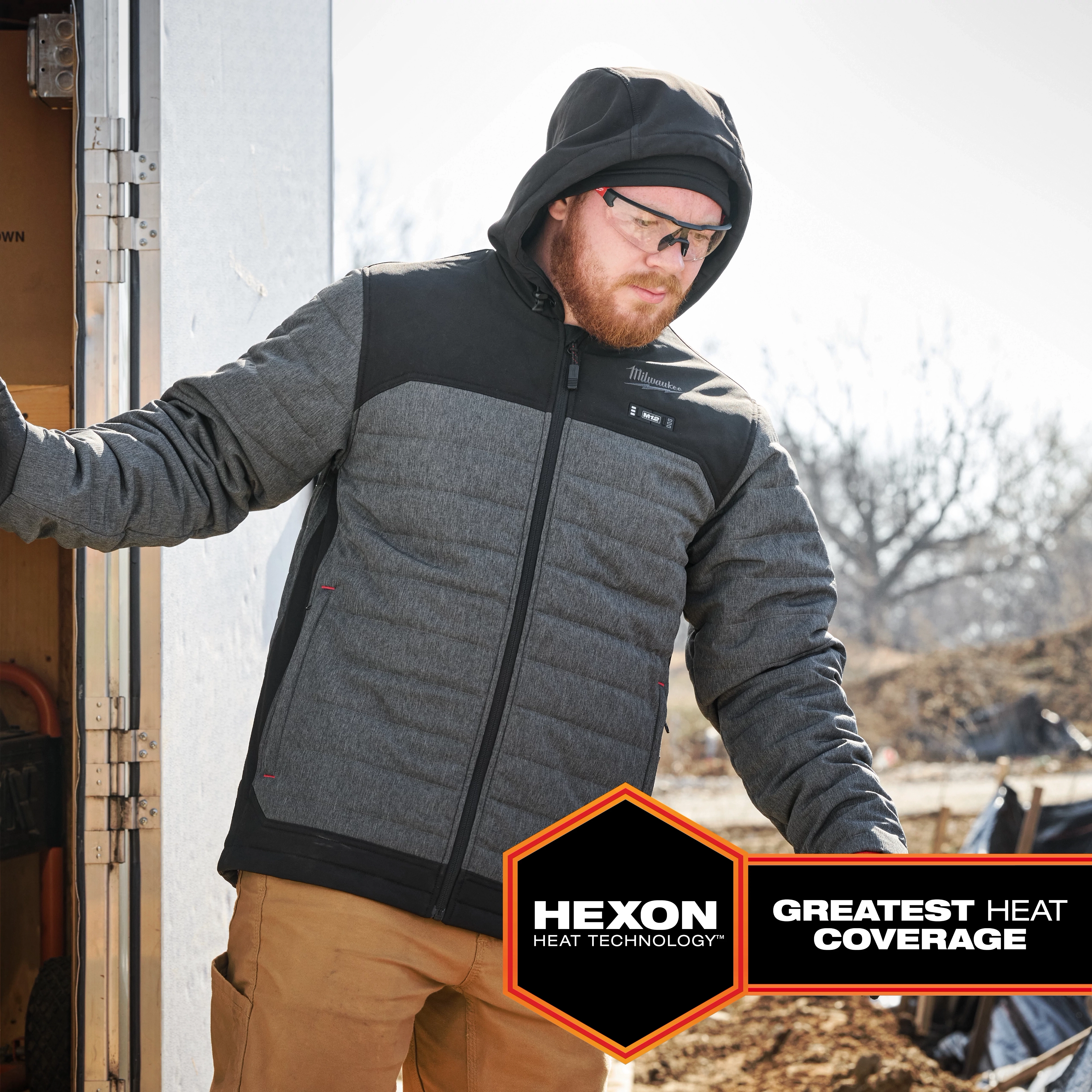 M12 Heated AXIS Jacket in gray and black with a hood, featuring Hexon Heat Technology for the greatest heat coverage.