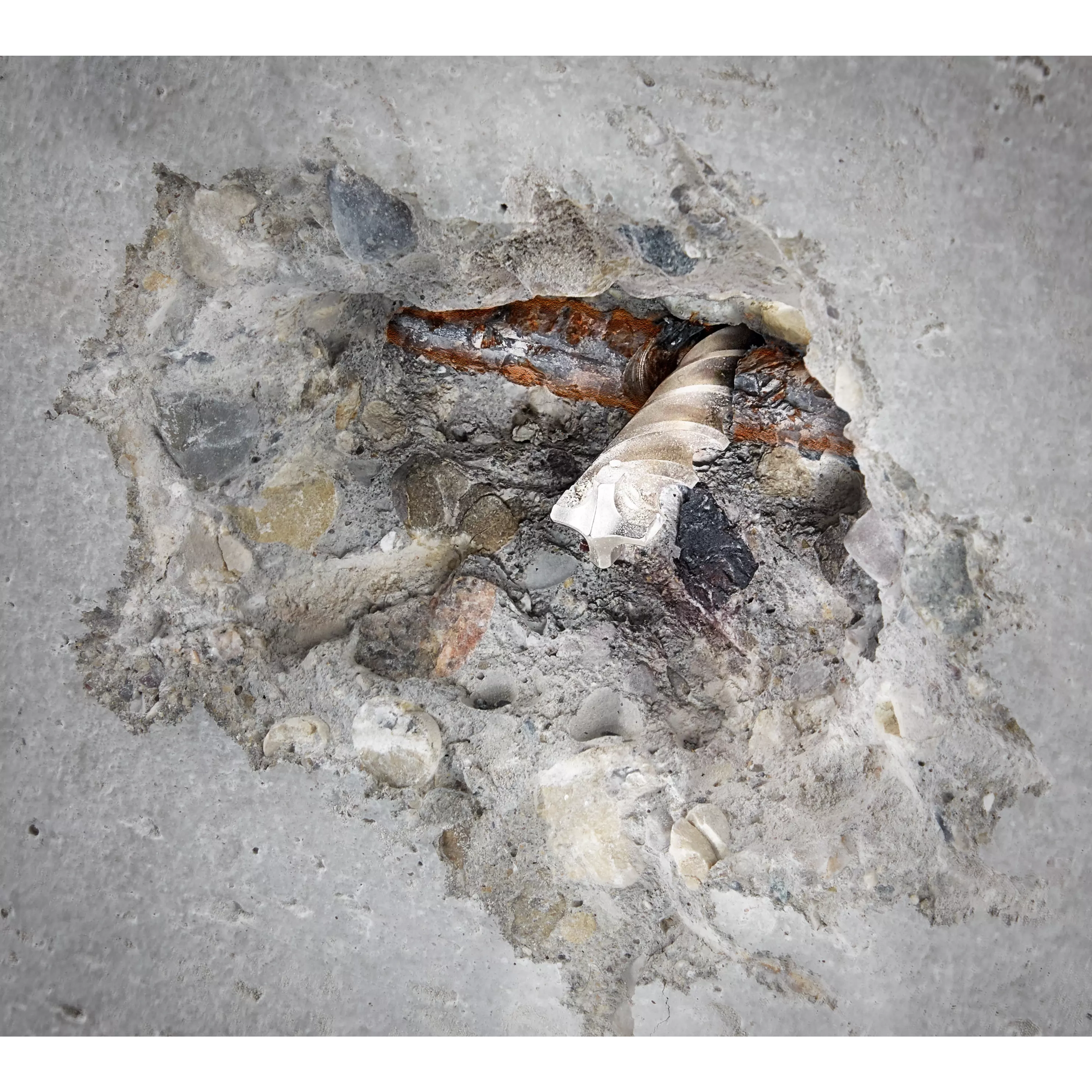 SDS-PLUS 4CT MX4 1/2" X 4" X 6" drill bit embedded in broken concrete, highlighting its drilling and chipping performance.