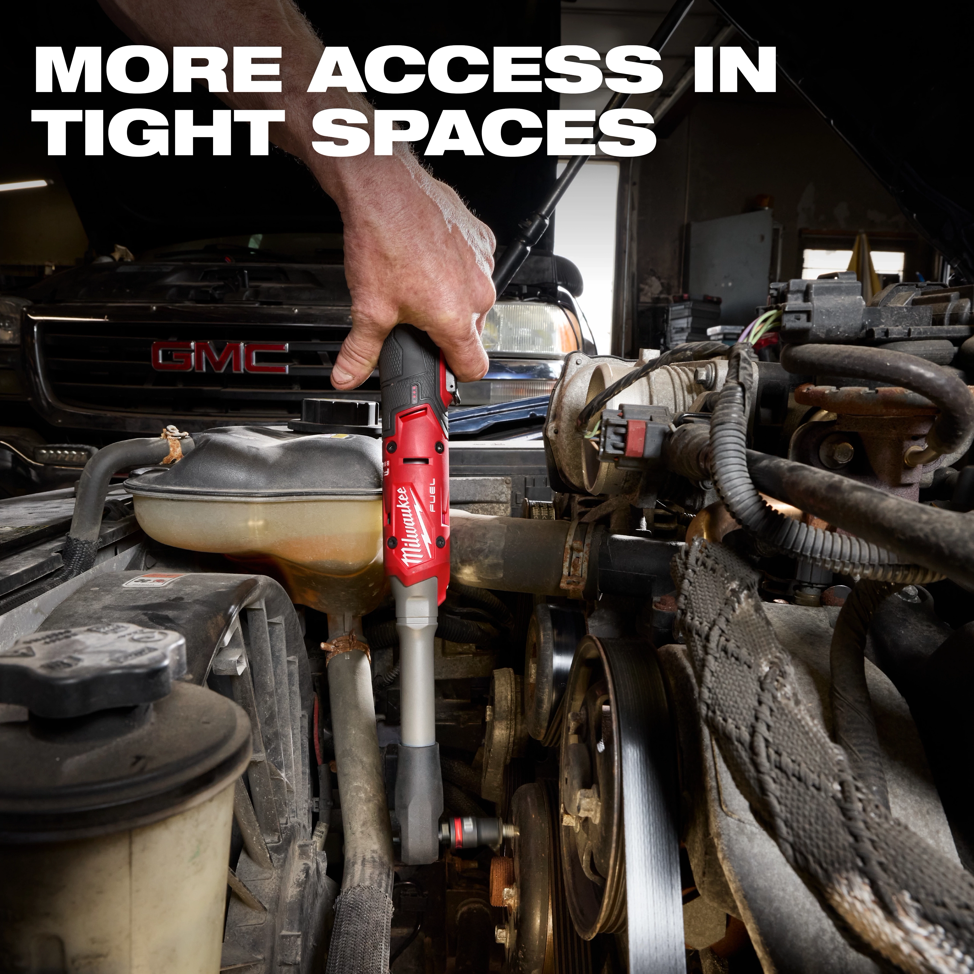 Hand using M12 FUEL 1/2" Extended Reach Ratchet to work on an engine in a tight under-hood space.