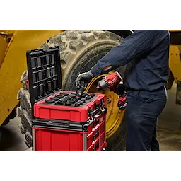 Worker using 21PC SHOCKWAVE Impact Duty 3/4" Drive Metric Standard Socket Set with PACKOUT near large vehicle tire.